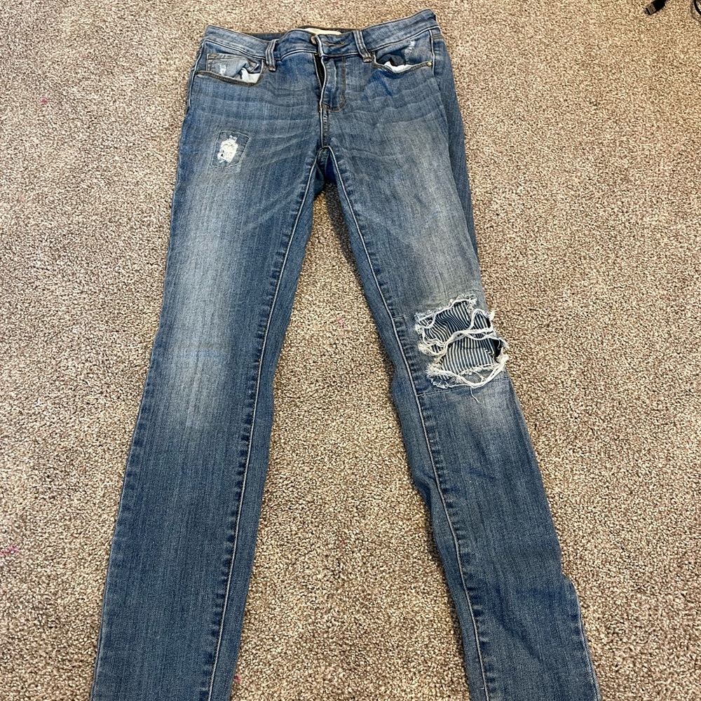 light wash ripped skinny jeans with cute piece of fabric sown under the knee rip
